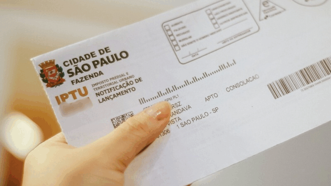 boleto de iptu de são paulo sendo segurando por uma pessoa