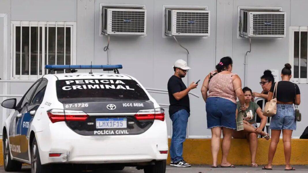 IML Pessoas estão ao lado de um carro da Perícia Criminal à espera de informações no IML