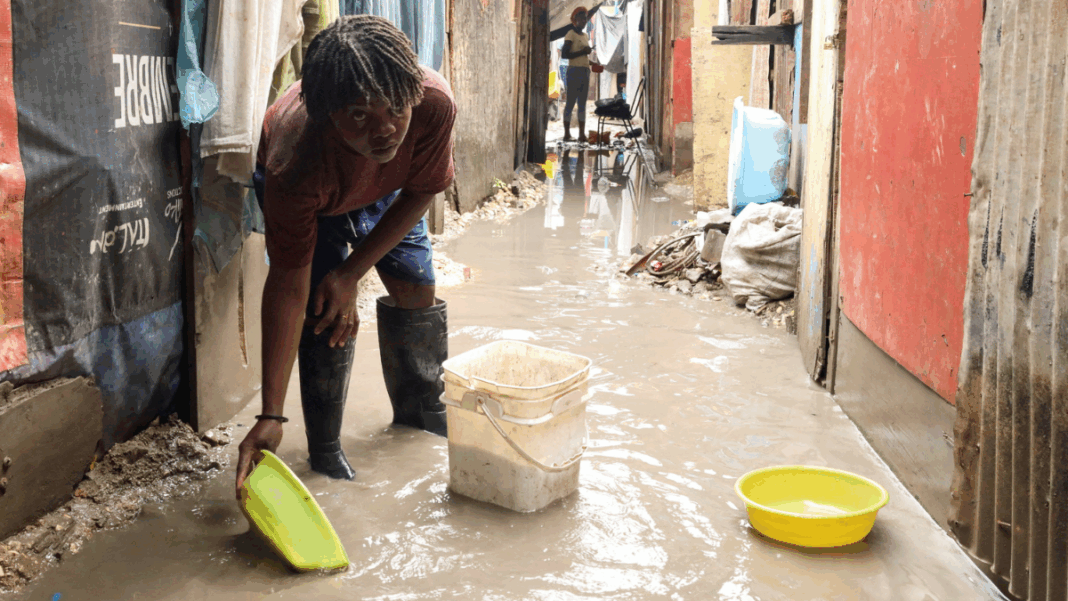 Melissa Mulher usa bacia para colher água do chão alagado numa rua estreia