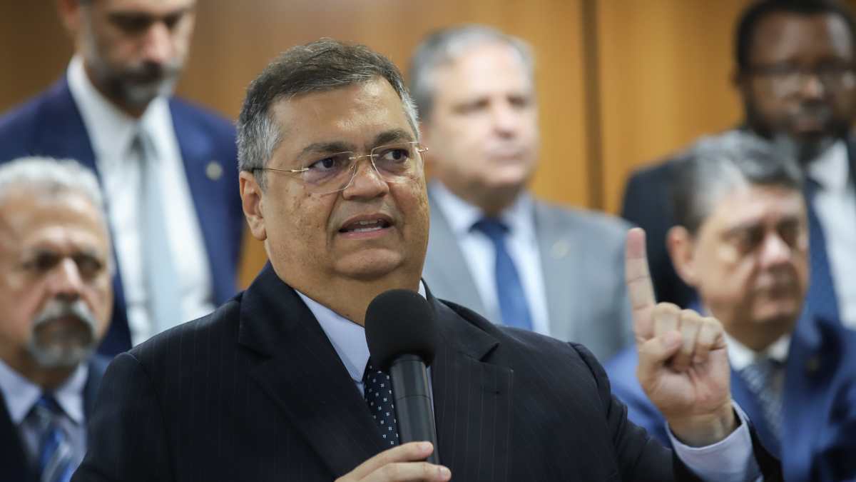 Na imagem, o ministro do Supremo Tribunal Federal, Flavio Dino, segura um microfone.