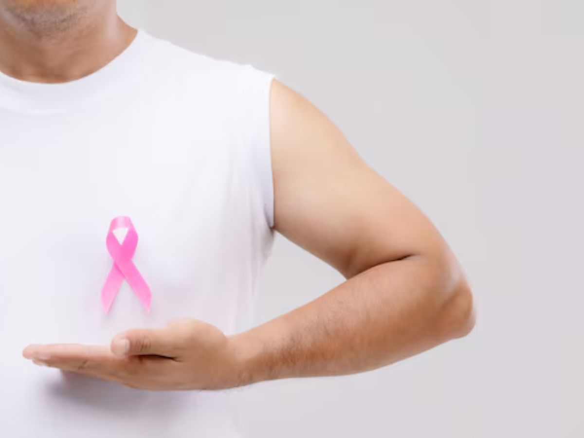 cancer-de-mama-tambem-afeta-homens Homem segurando uma fitinho de outubro rosa