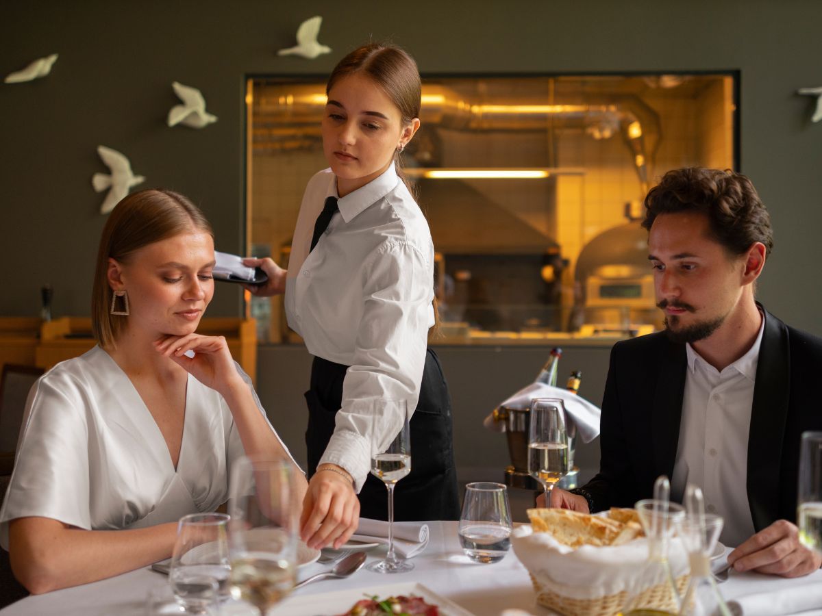 garconete-servindo Garçonete servindo uma mesa com casal