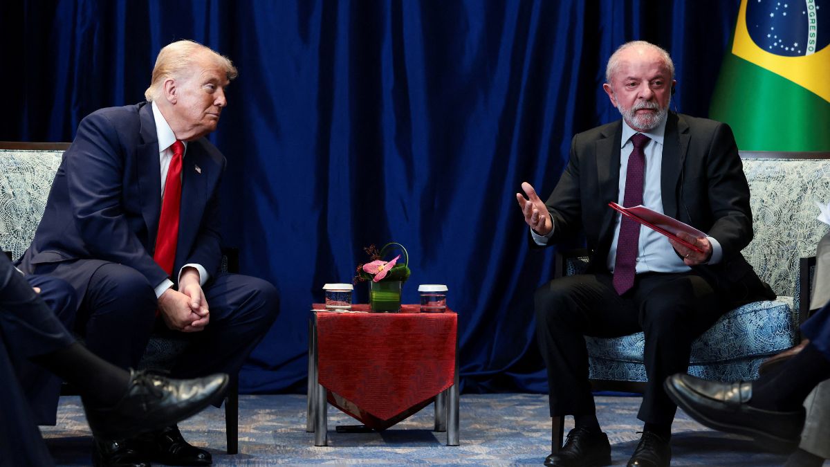 lula e trump malásia REUTERS Evelyn Hockstein Uma foto em plano médio, que captura o momento de uma reunião formal, mostrando Donald Trump e Luiz Inácio Lula da Silva sentados de frente um para o outro, separados por uma pequena mesa.