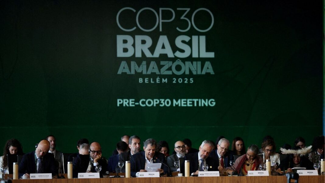Políticos sentados em evento de abertura na COP30. Ao fundo, uma parede verde com os dizeres COP 30-BRASIL-AMAZÔNIA-PRE-COP30 MEETING