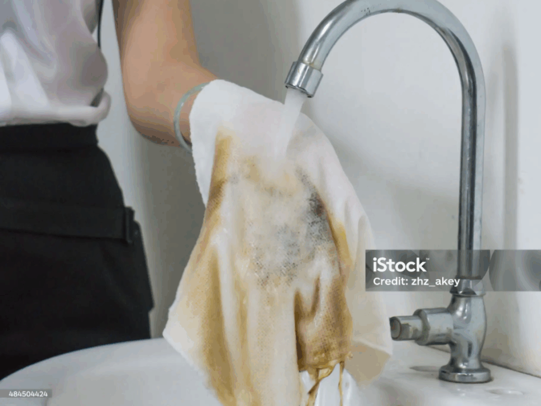 Pessoa lavando pano sujo.